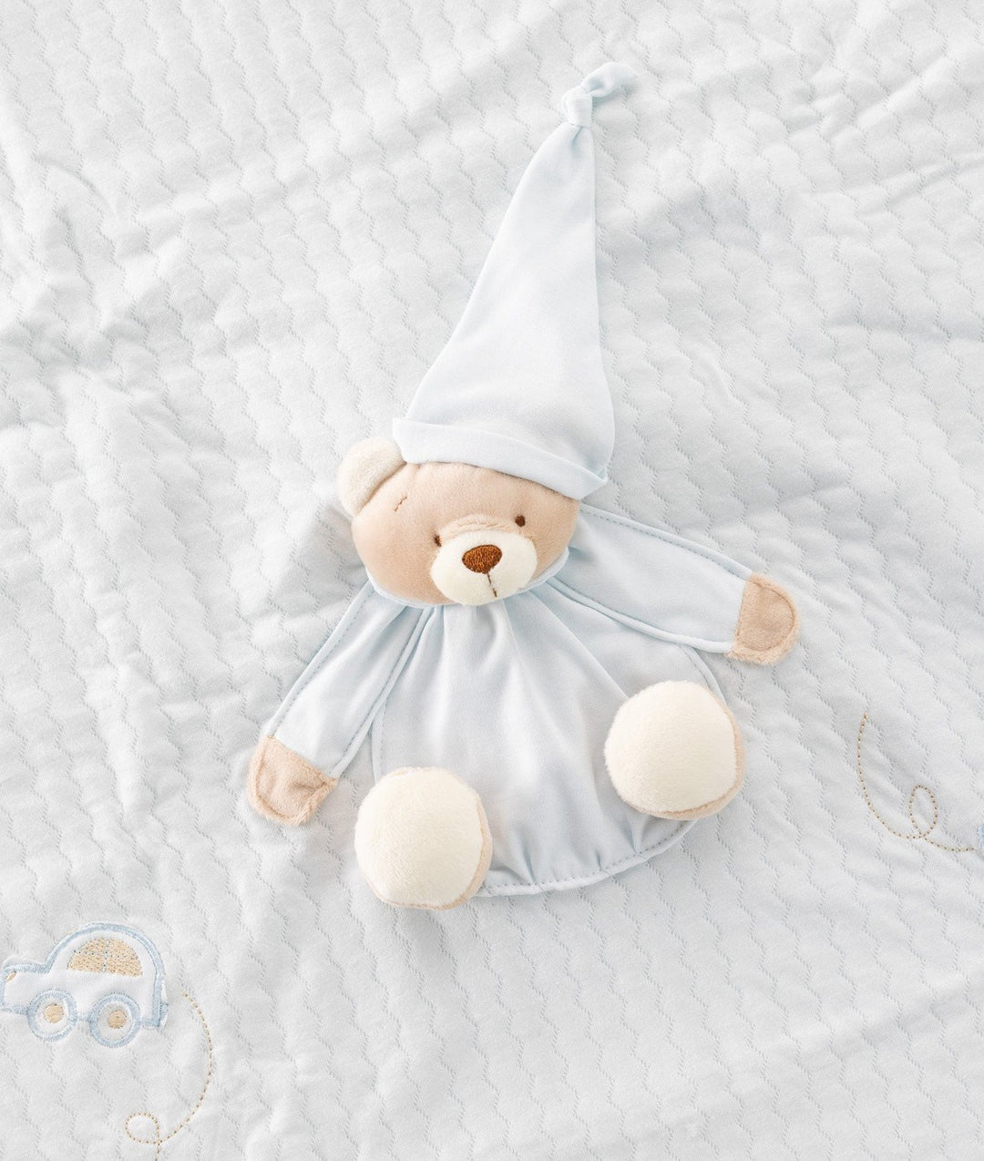 Close-up of light blue baby blanket stitching on 3D bear face and toy car