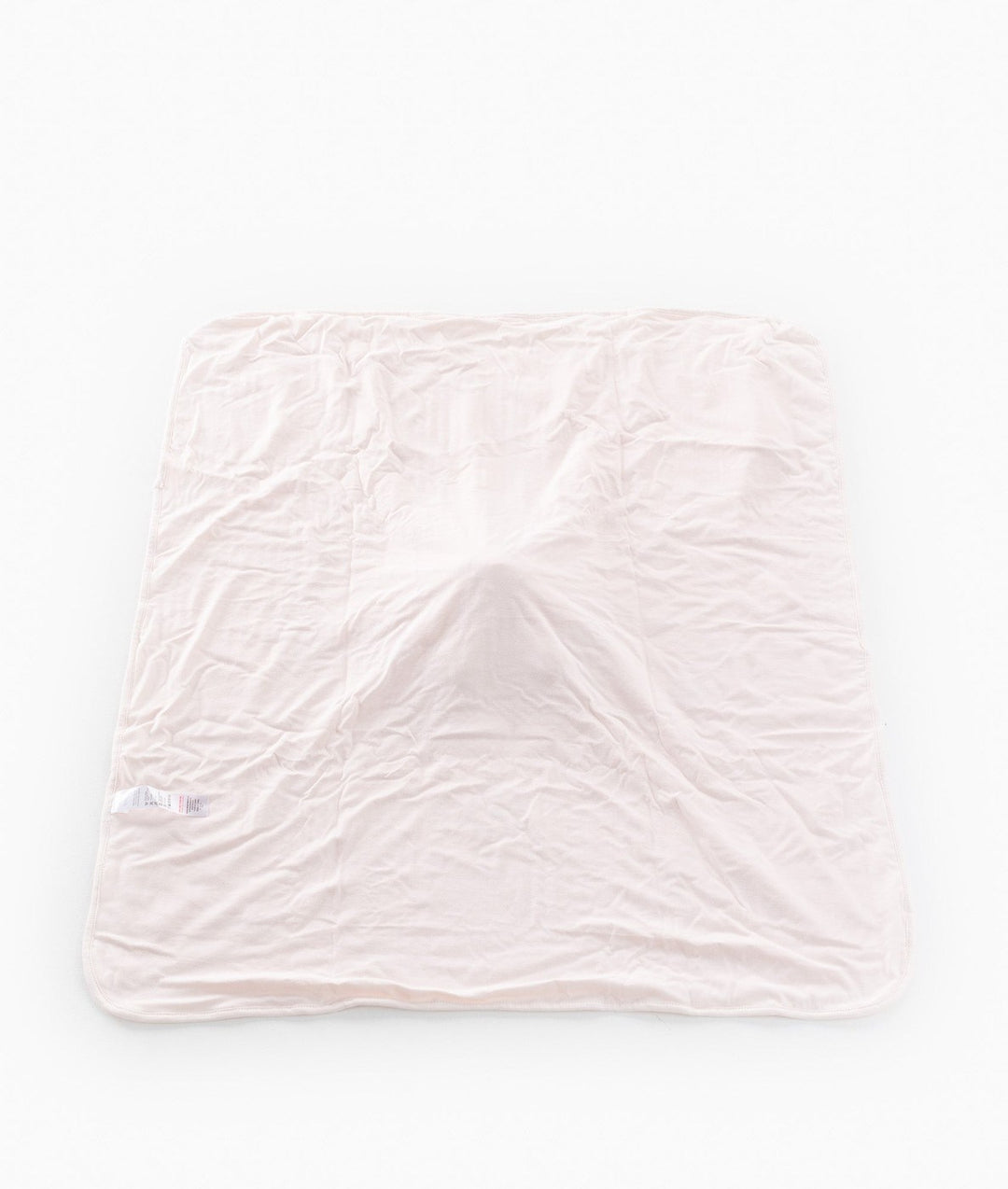 Back of pink baby blanket showing smooth cotton fabric and care label