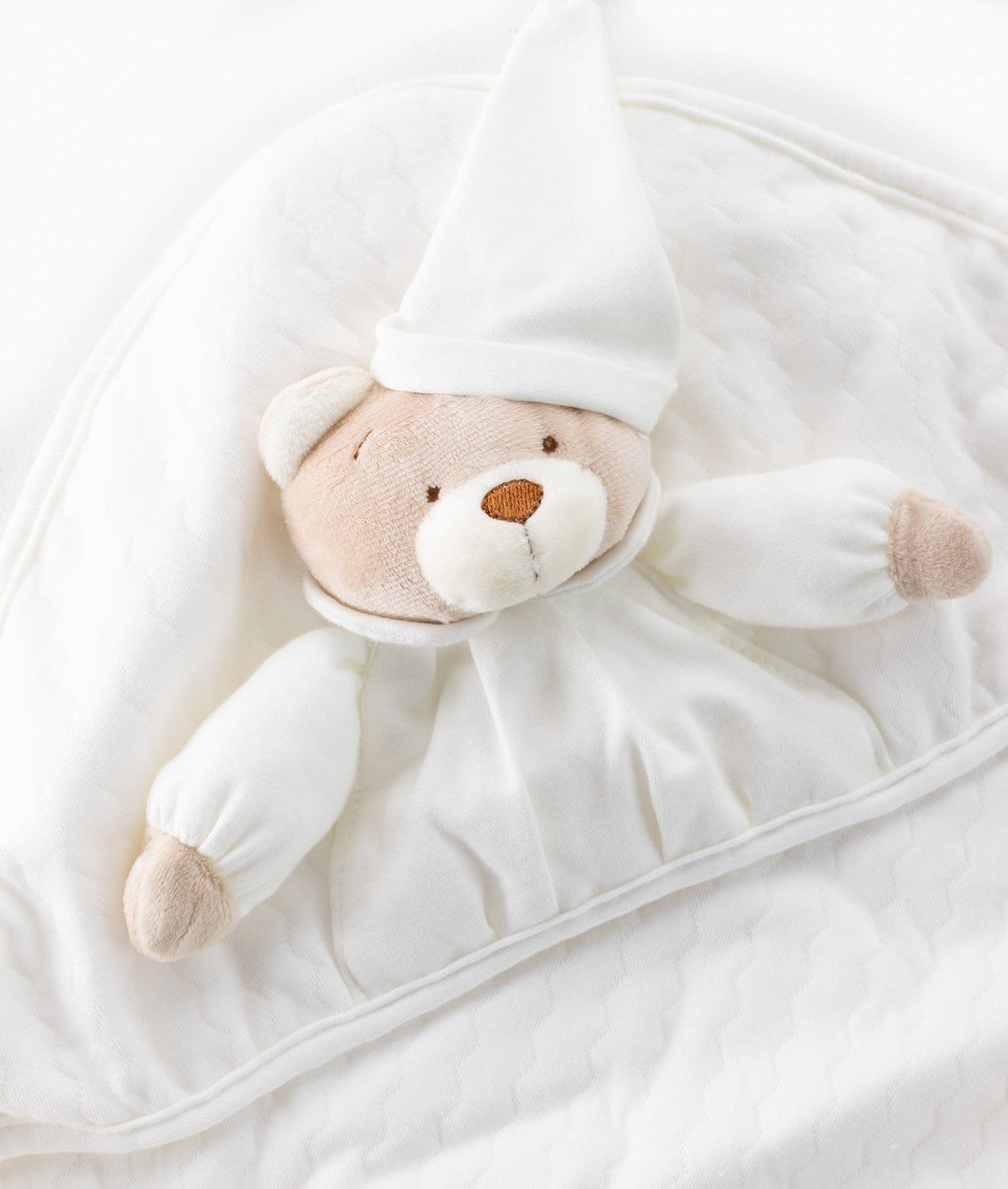 Close-up of textured quilted fabric on 3D beige bear baby swaddle