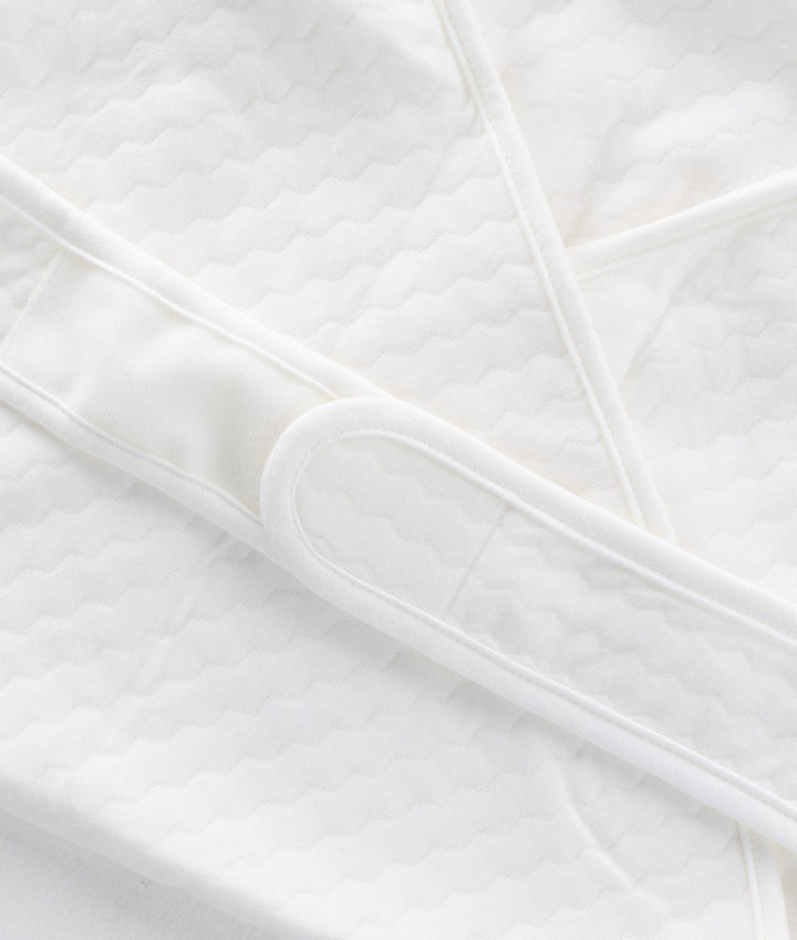 Macro detail of wavy quilted 100% cotton texture and loop fastener on swaddle