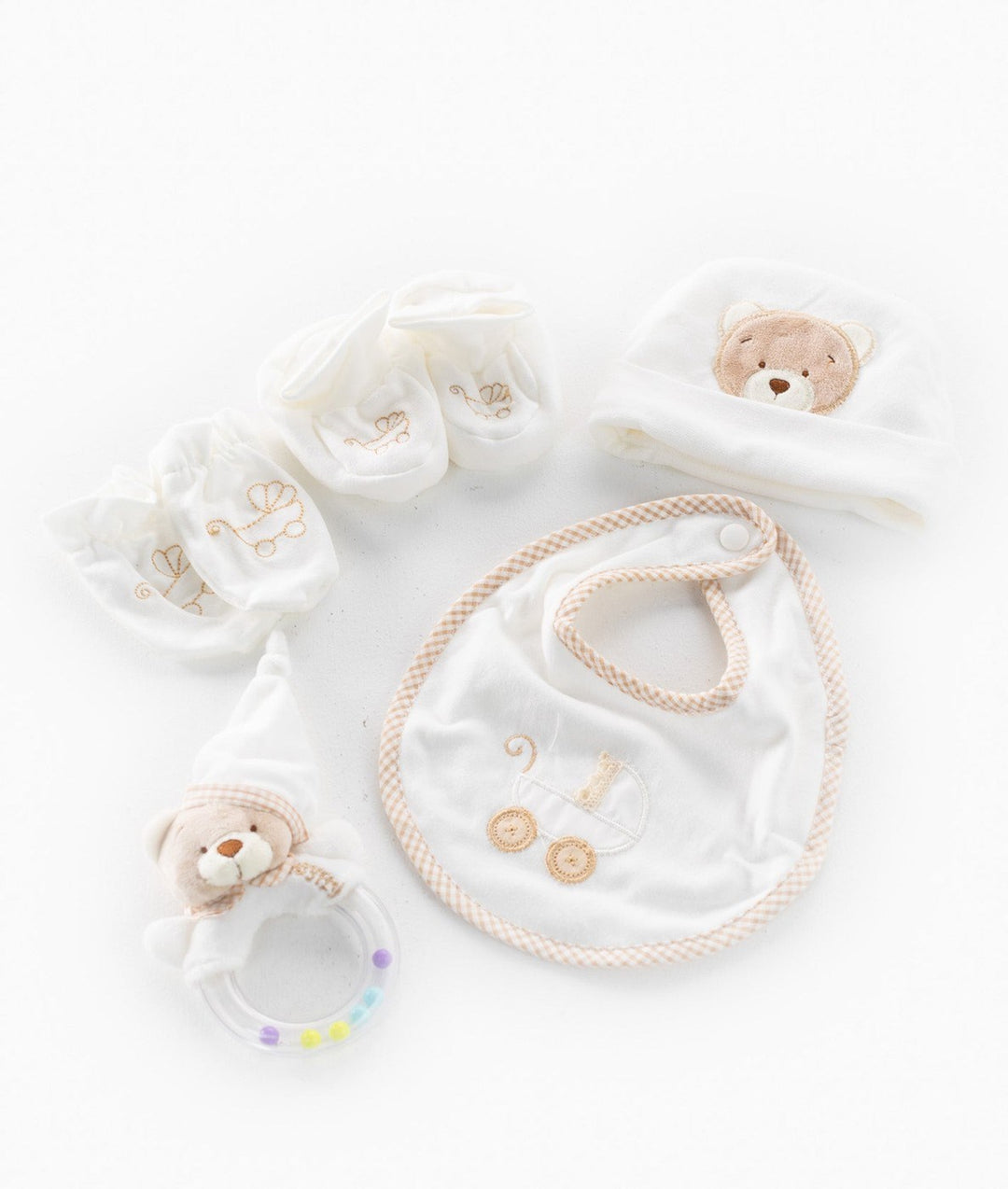 5-piece beige and white newborn gift set flat lay with rattle and booties