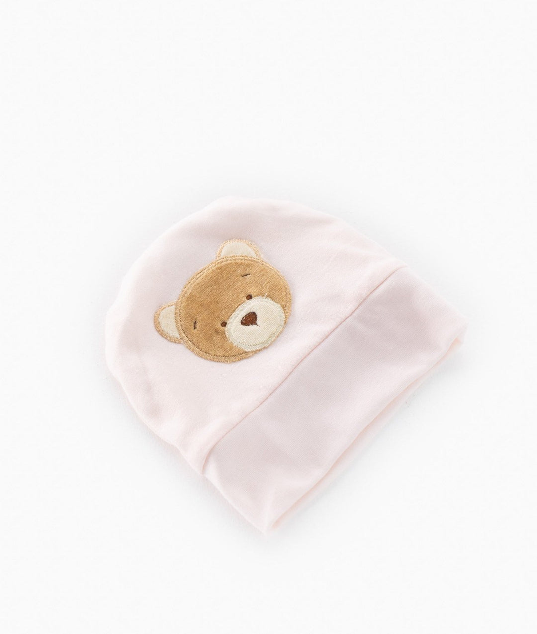Pastel pink newborn hat with brown bear face detail and elasticated cuff overhead shot