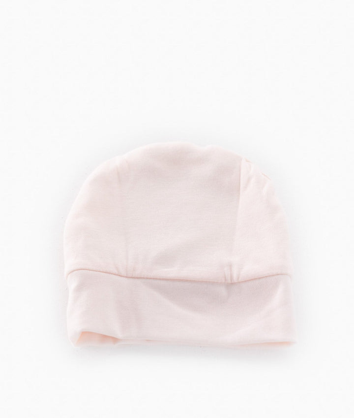 Back view of pale pink baby cotton beanie with seamless crown and ribbed cuff