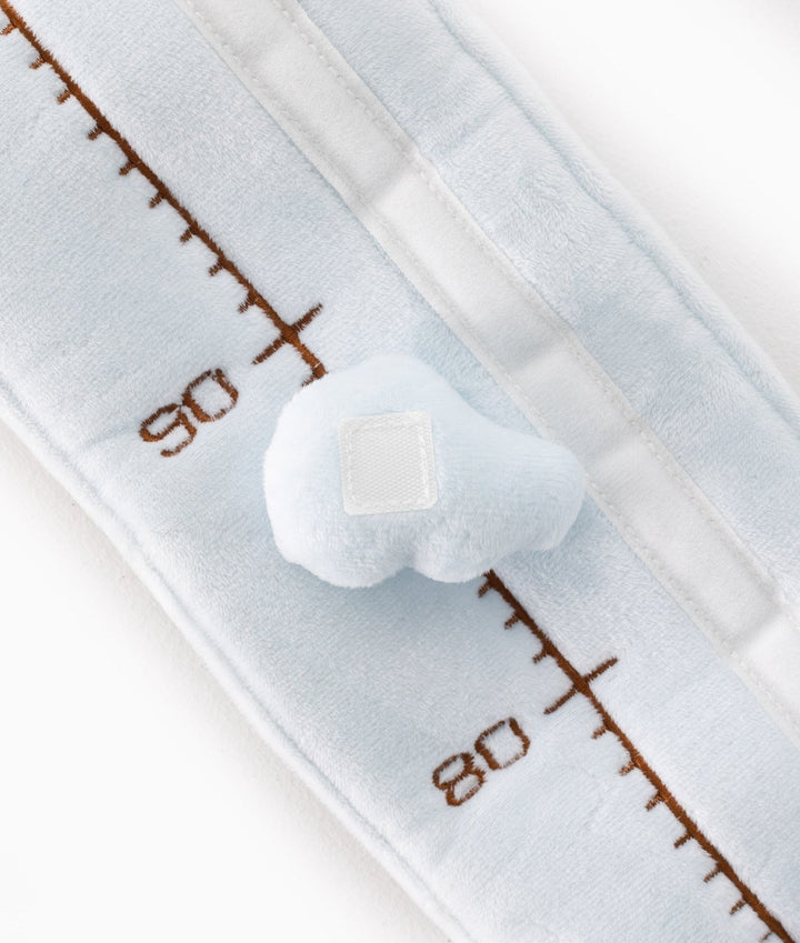 Close-up of soft light blue plush texture with brown embroidered measurement lines
