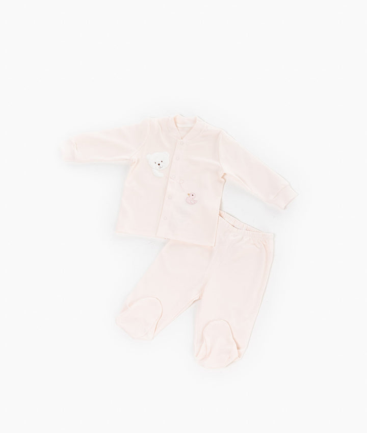Pink baby pyjama set with teddy bear applique and footed pants flat lay