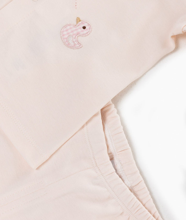 Close up of pink cotton fabric with gingham duck embroidery patch on waistband