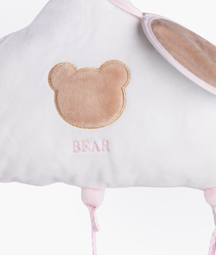 Detail shot of brown embroidered bear head outline on white plush fabric