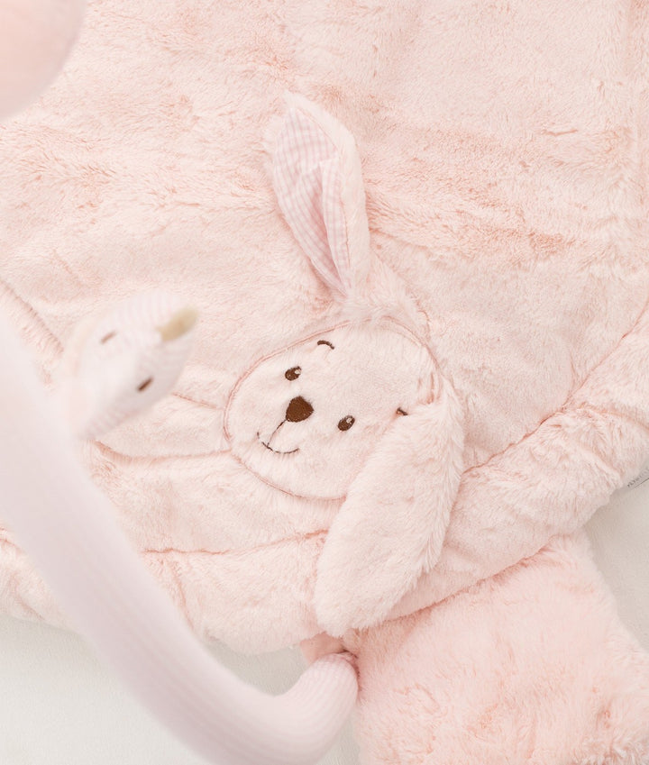 Macro shot of dense plush pink playmat texture with embroidered bunny face and gingham ears
