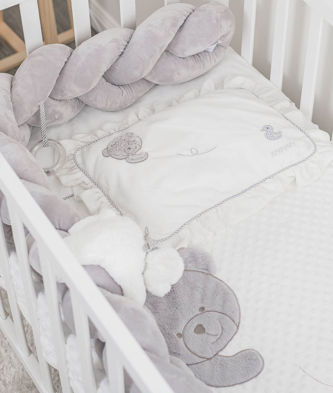 grey velvet bolster and ruffled pillow with bear duck embroidery in crib