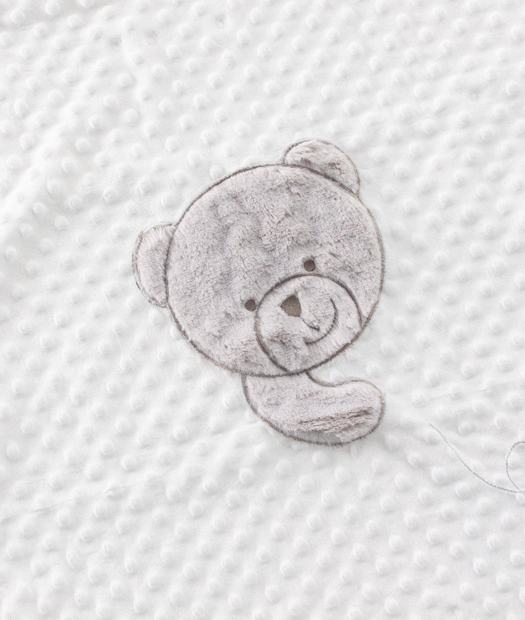 Close up of grey teddy bear patch on white raised bubble texture