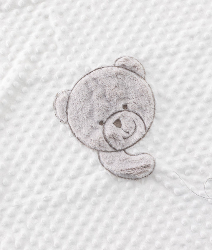Close up of grey teddy bear patch on white raised bubble texture