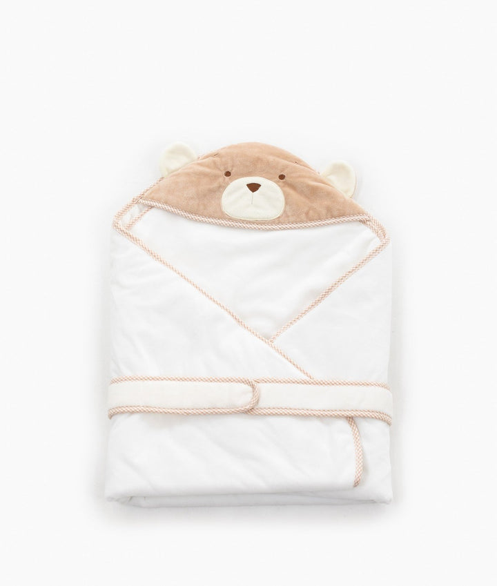 Folded white swaddle with beige trim tie strap for snug baby wrap