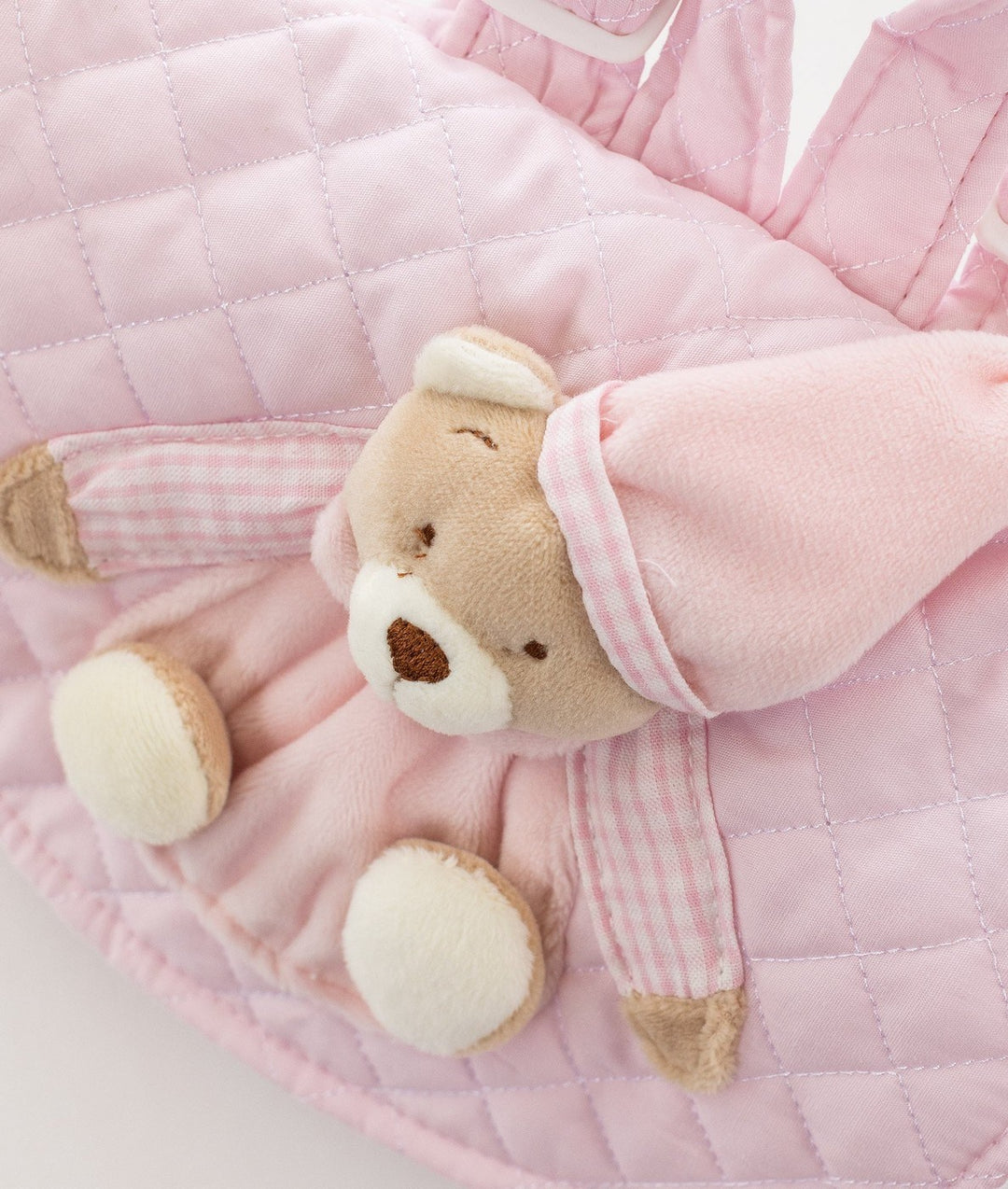 Close-up of plush teddy bear accent on pink flap with checkered sleeve