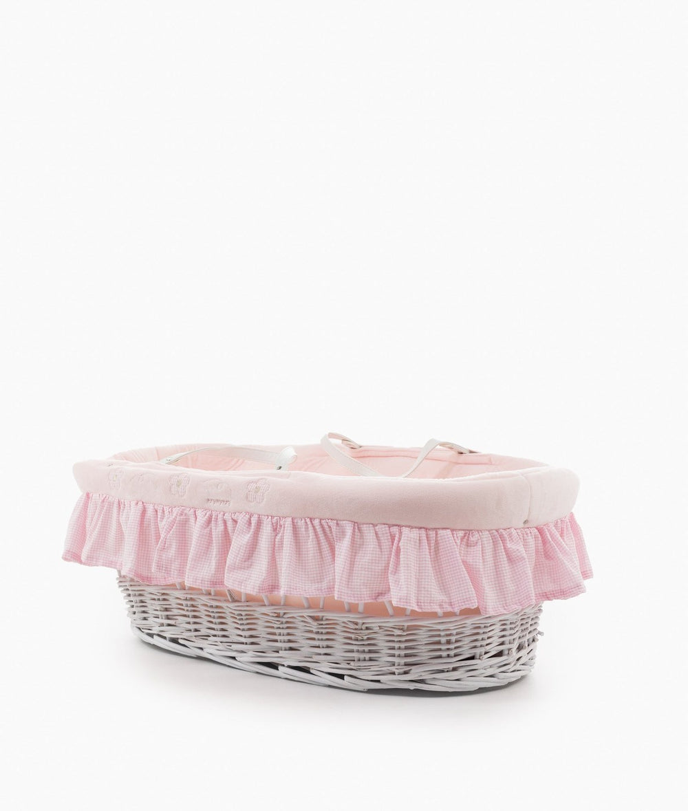 White wicker Moses basket with pink cotton liner and safety straps