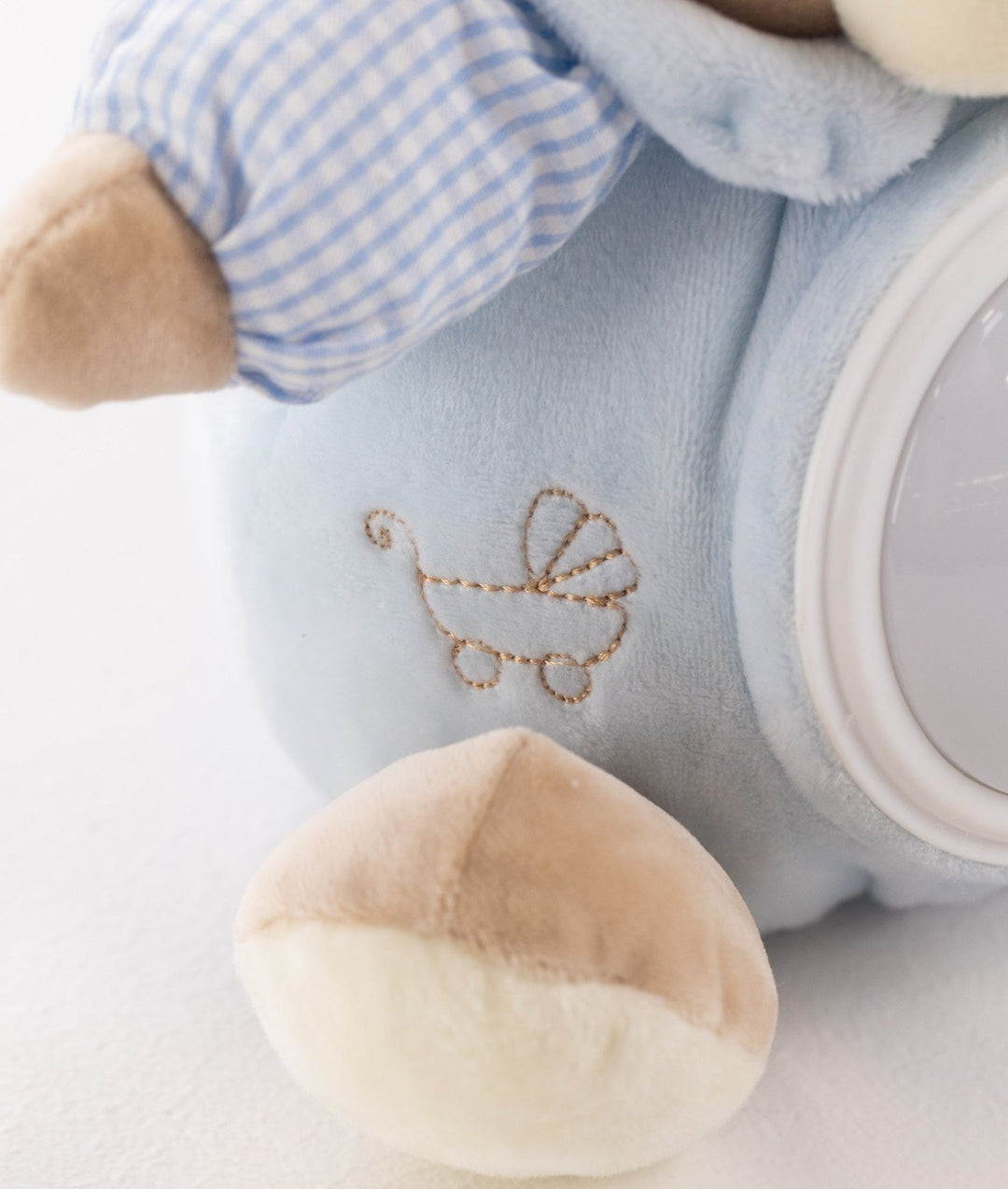 Macro shot of blue night light featuring gold thread baby carriage embroidery