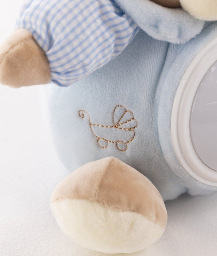 Macro shot of blue night light featuring gold thread baby carriage embroidery