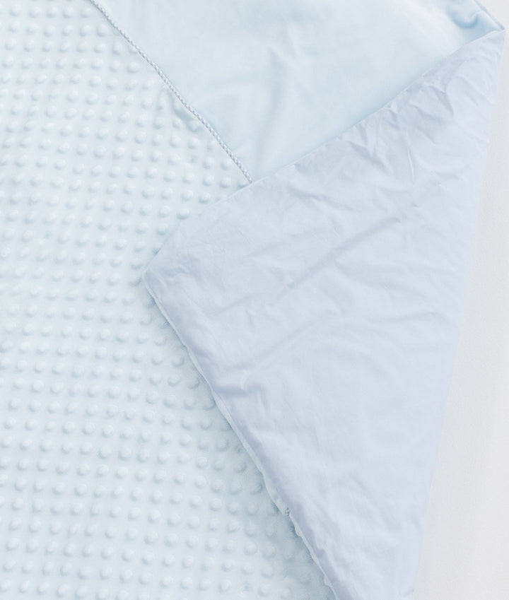 Folded light blue bubble quilt revealing smooth outer cover and precise seam stitching