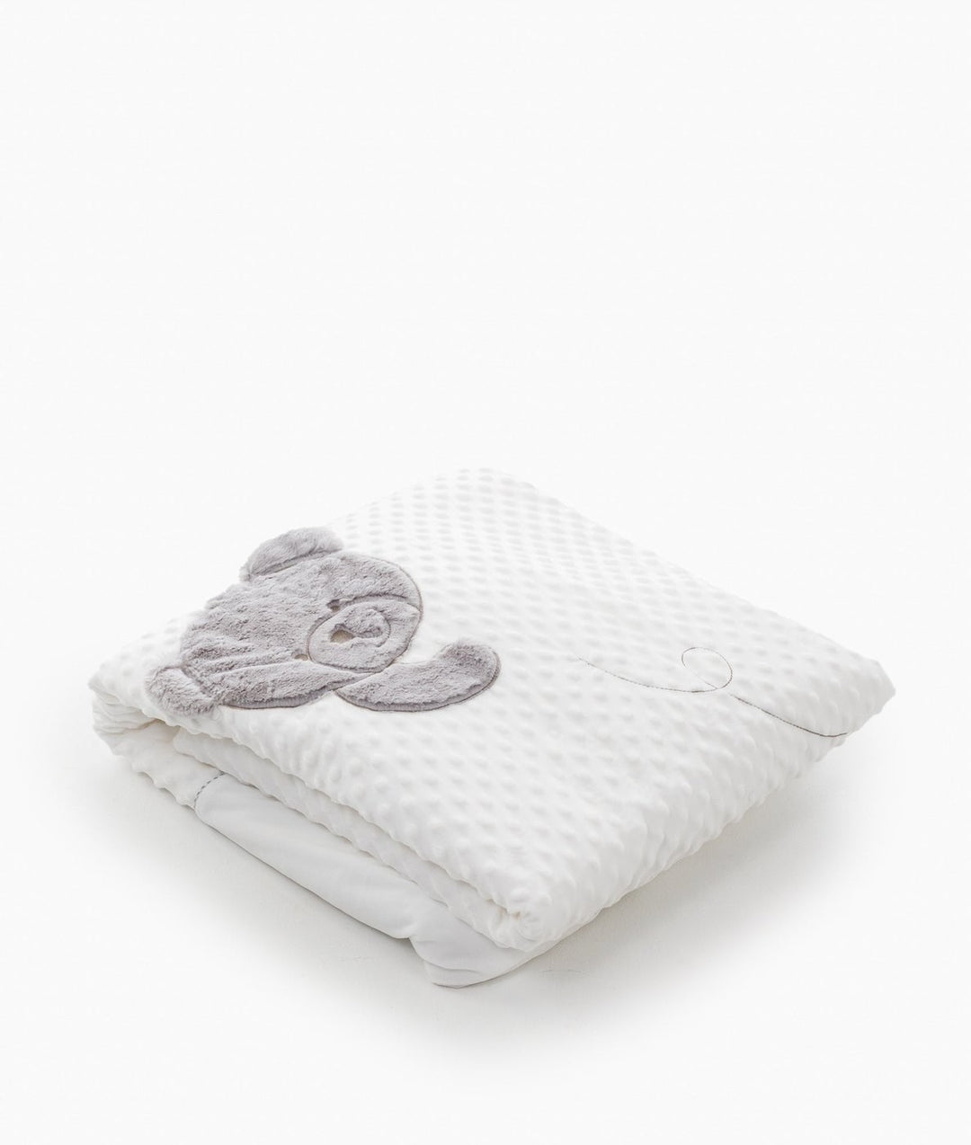 Folded white toddler bubble quilt with grey teddy bear appliqué